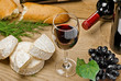 Red wine, Brie and Camembert cheeses with bread on the table