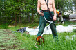 © Kekyalyaynen - Unrecognizable man a lawn-mower with weed trimer on lawn