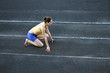 © denys_kuvaiev - Athletic teenage girl in start position on track .