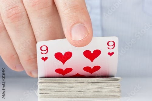 Photographie hand revealing nine of hearts
