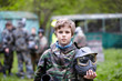 © Pavel Losevsky - Boy in camouflage holds paintball gun barrel up in one hand
