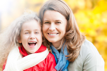 Poster - Happy young mother and small daughter in autumn park.