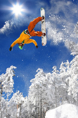 Wall Mural - Snowboarder jumping against blue sky