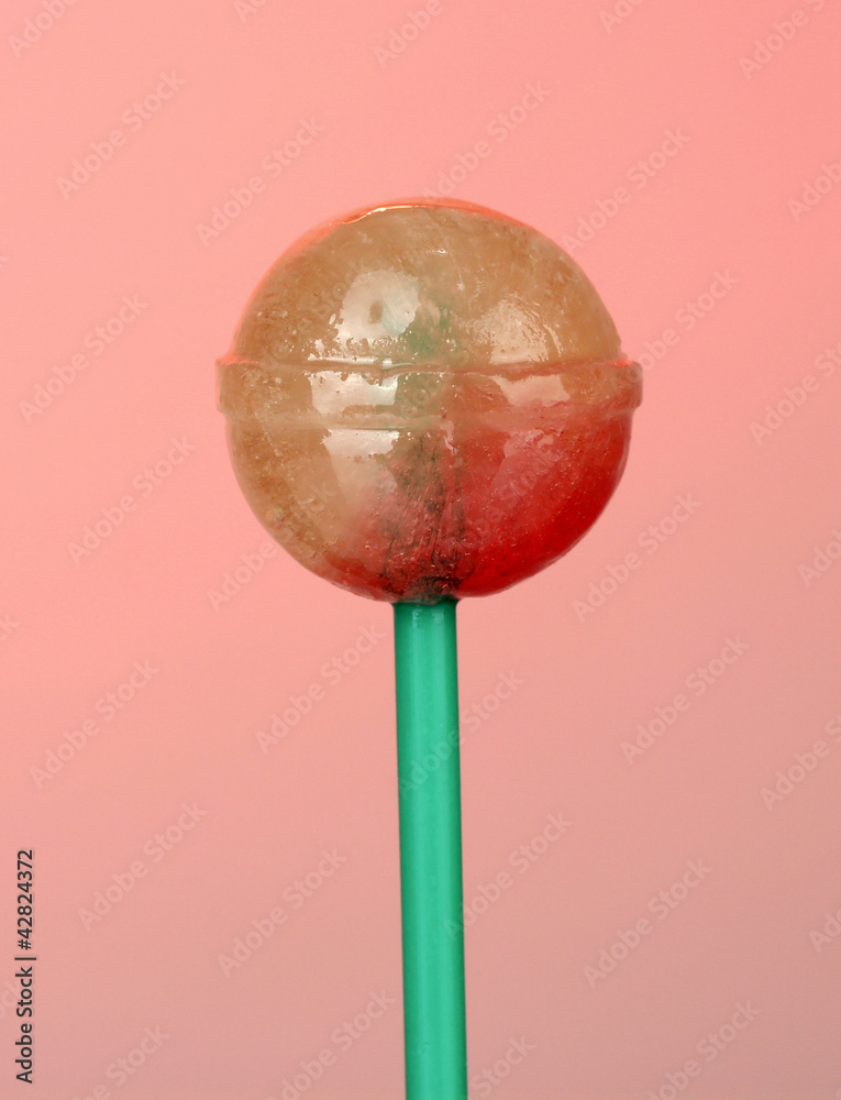 Sweet and tasty lollipop on pink background close-up