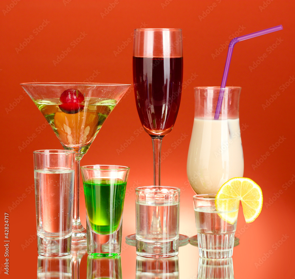 a variety of alcoholic drinks on red background