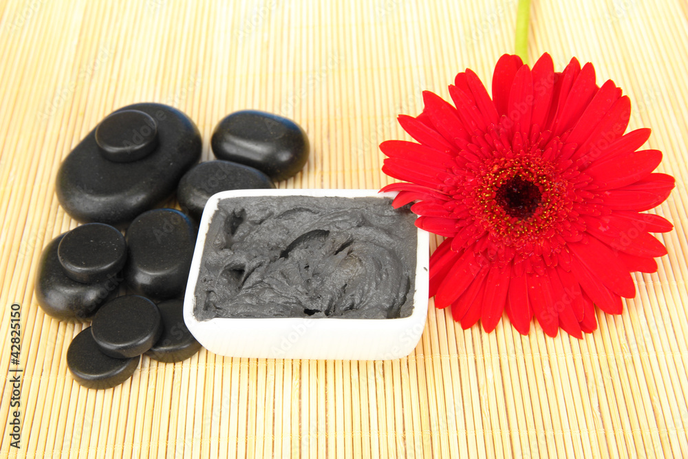 cosmetic clay for spa treatments on straw background close-up