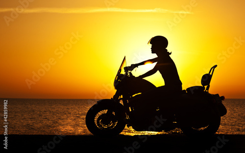 Naklejka dekoracyjna Woman biker over sunset