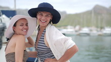 Two Women Smiling To Camera At Marina, Steadycam Shot