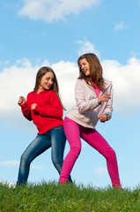 Wall Mural - Two teenage girls having fun outdoor on sunny spring day