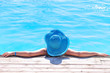 Woman in hat relaxing at swimming pool
