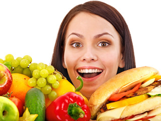 Woman choosing between fruit and hamburger.