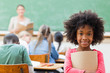 © Wavebreak Media - Smiling girl standing in classroom