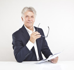 successful mature businessman looking at camera at work in offi