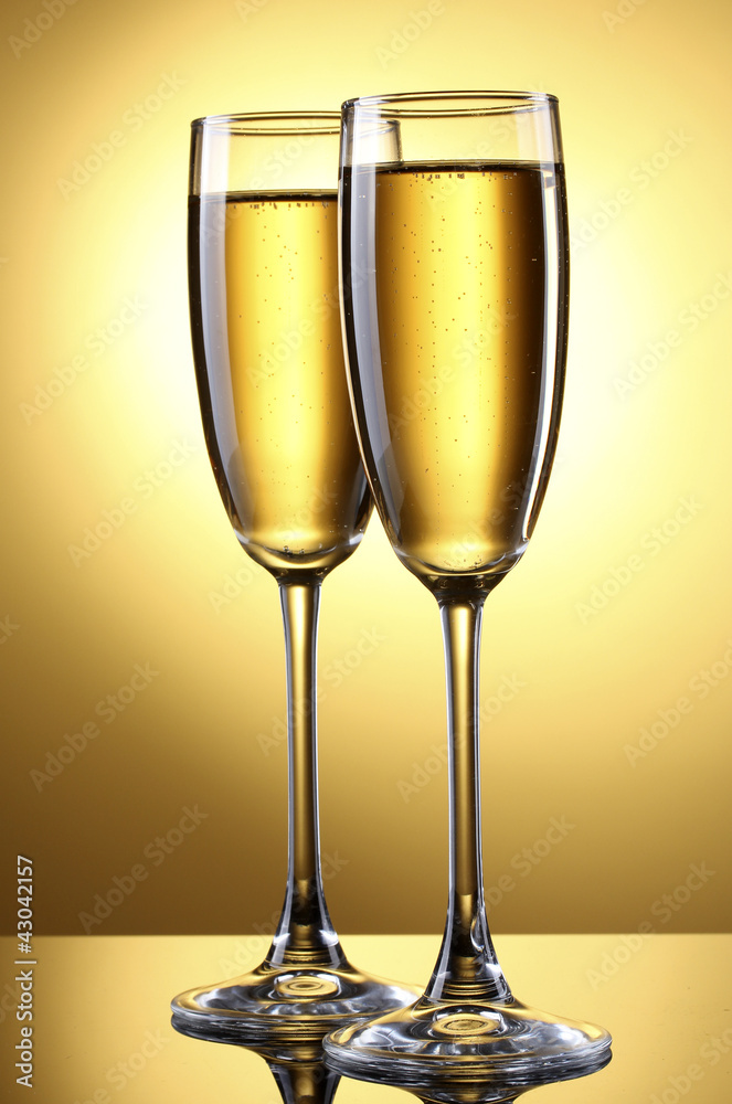 glasses of champagne on yellow background