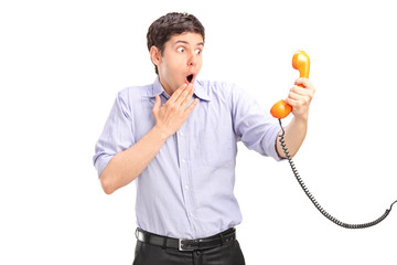 Wall Mural - a shocked man holding a telephone tube