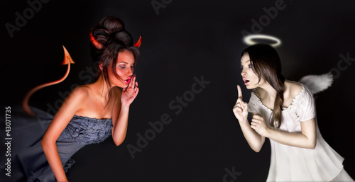 Foto Portrait der Engels- und Teufelmädchen und des copyspace zwischen ihnen