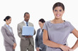 © WavebreakmediaMicro - Woman with hands on her hips with business team in the backgroun