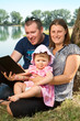 © Lsantilli - Happy family with books on the nature near lake
