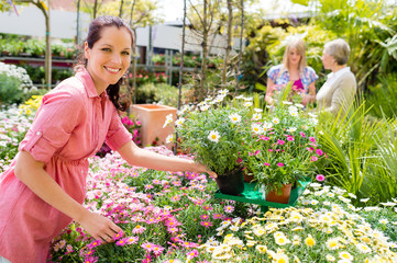 Florist arranging flower pots in garden store