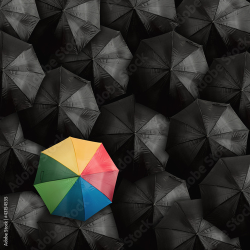 parasol-w-kolorach-teczy-na-tle-innych-czarnych-parasoli