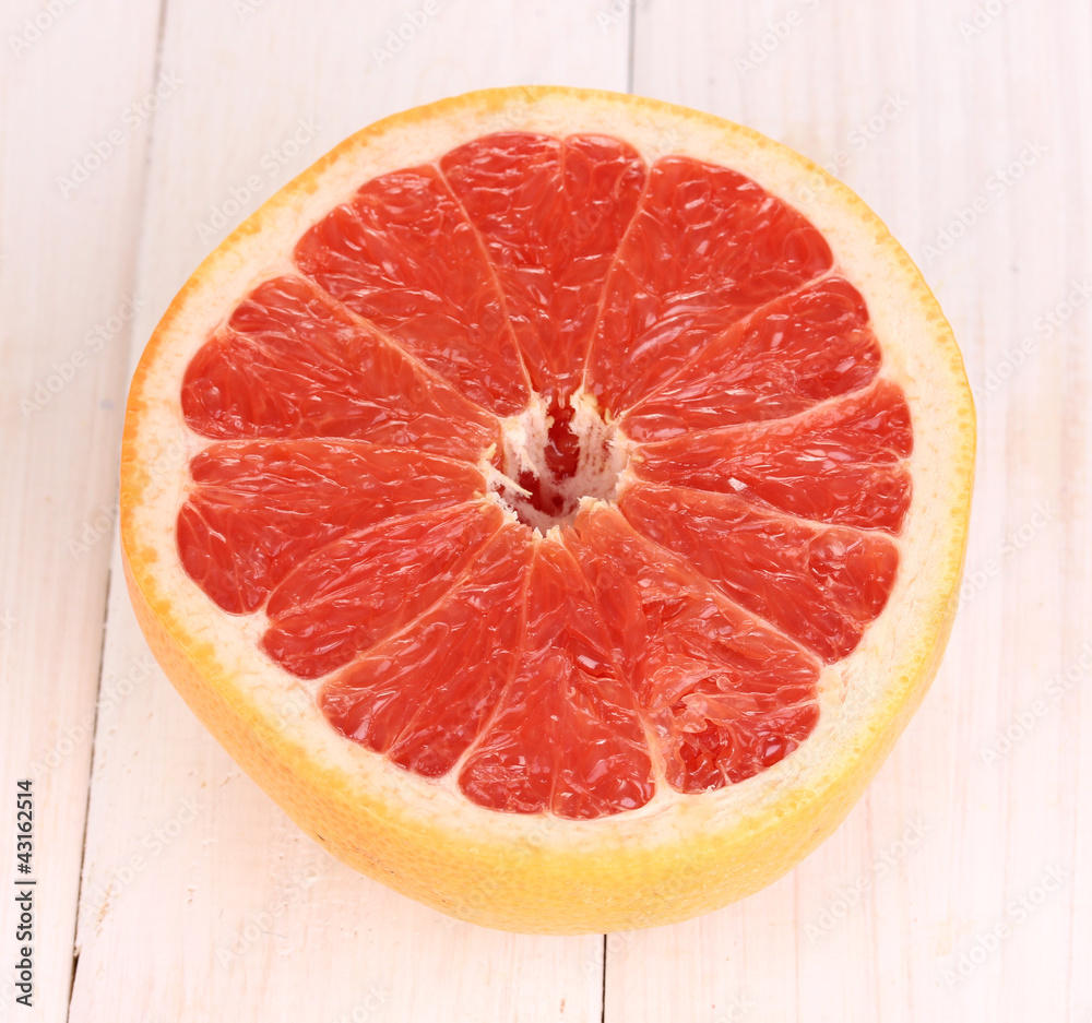 Half of ripe grapefruit on wooden background