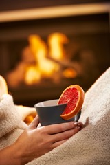 Having hot tea in front of fireplace