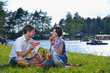 Wall Mural - happy young couple having a picnic outdoor