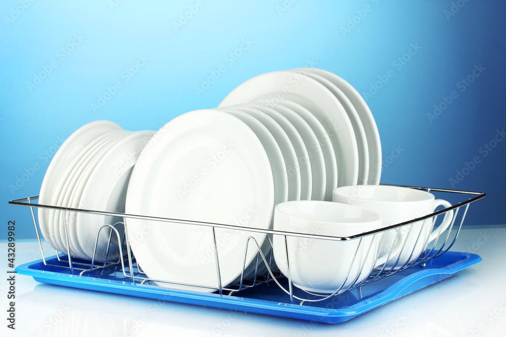 clean dishes on stand on blue background