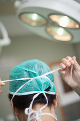 Wall Mural - Woman surgeon putting a surgical hat on