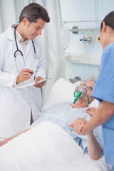 Wall Mural - Doctor looking at patient next to a nurse