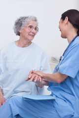 Wall Mural - Nurse and a patient sitting on a bed