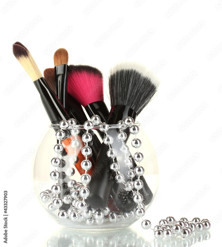 Make-up brushes in a bowl with pearl necklace isolated on white