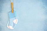 Fototapeta Uliczki - Blue baby socks on a textured background