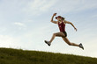© Pete Saloutos/Blend Images - Caucasian runner running in field