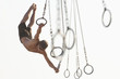 © Eric Raptosh Photography/Blend Images - Mixed race man swinging on athletic rings