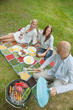 Friends Eating Food At An Outdoor Picnic