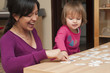 © GM Visuals/Blend Images - Hispanic mother and daughter playing card game