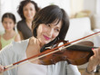 © JGI/Jamie Grill/Blend Images - Mother and daughter watching grandmother playing violin