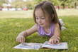 © REB Images/Blend Images - Hispanic girl laying in grass reading book