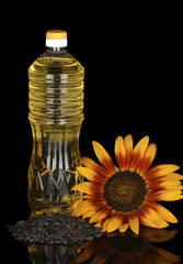 Wall Mural - sunflower oil in a plastic bottle isolated on black background