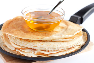 Wall Mural - Round pancakes in a frying pan and honey