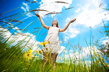 Attractive brunette girl on a green blossoming meadow