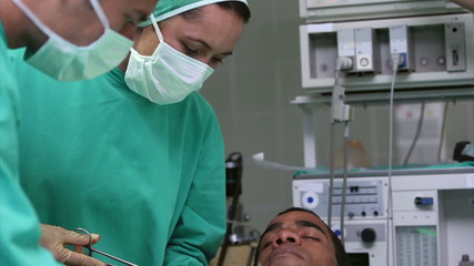 Wall Mural - Serious doctors operating a patient