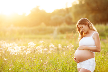 beautiful pregnant woman relaxing in the park