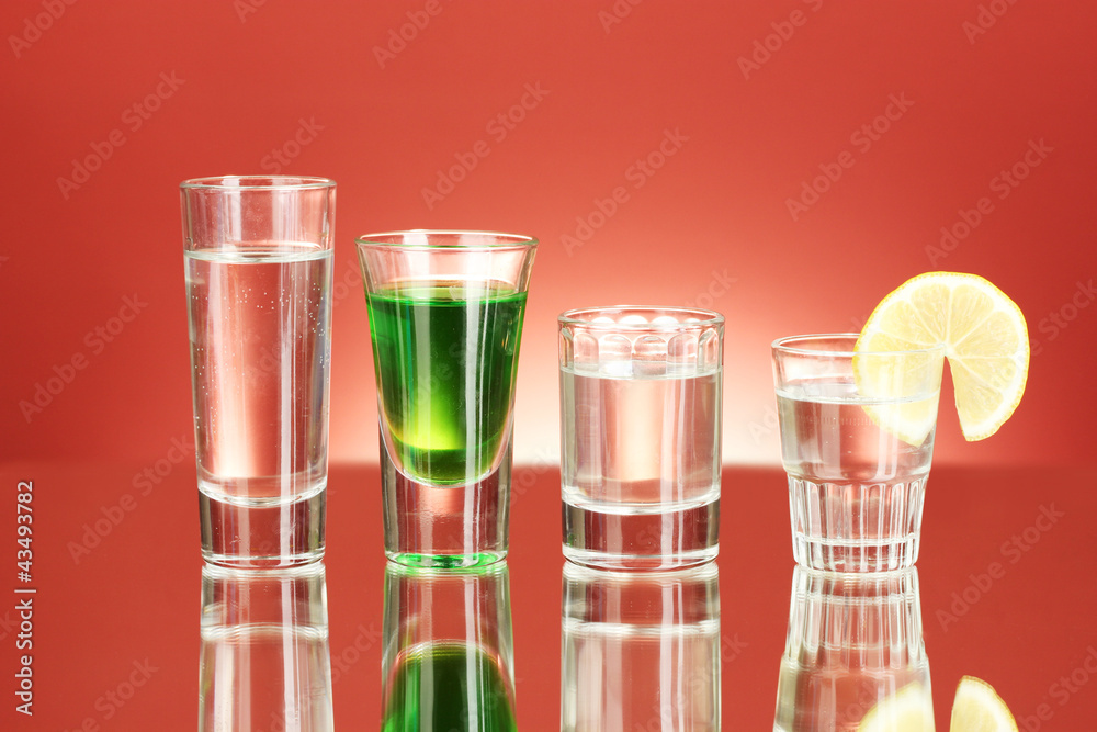 a variety of alcoholic drinks on red background