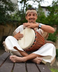 Portrait of young latino percusionist playing african drums