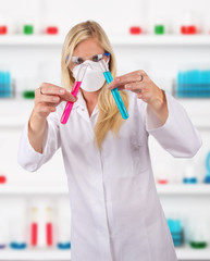 Wall Mural - Young attractive laboratory assistant researching test tubes