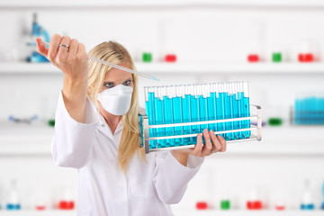 Wall Mural - Young attractive laboratory assistant droping chemical liquid