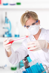 Wall Mural - Young attractive laboratory assistant pouring chemical liquid