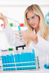 Wall Mural - Young attractive laboratory assistant droping chemical liquid